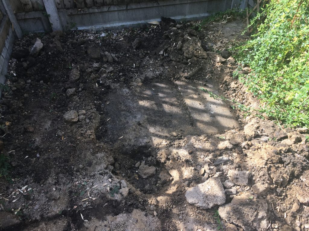 concrete slab buried under small london terrace house backyard